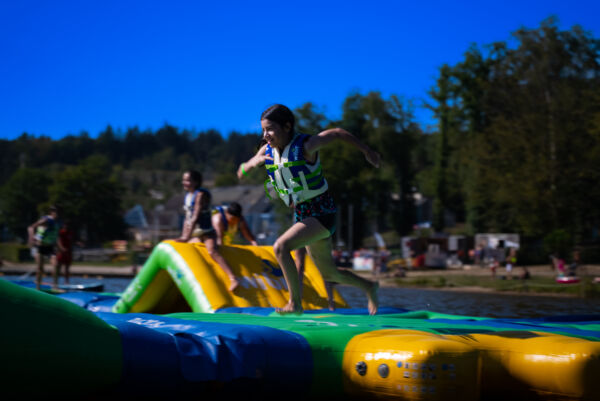 Enfant courant sur le module "Curve" du Wi Splash au lac des Vieilles Forges